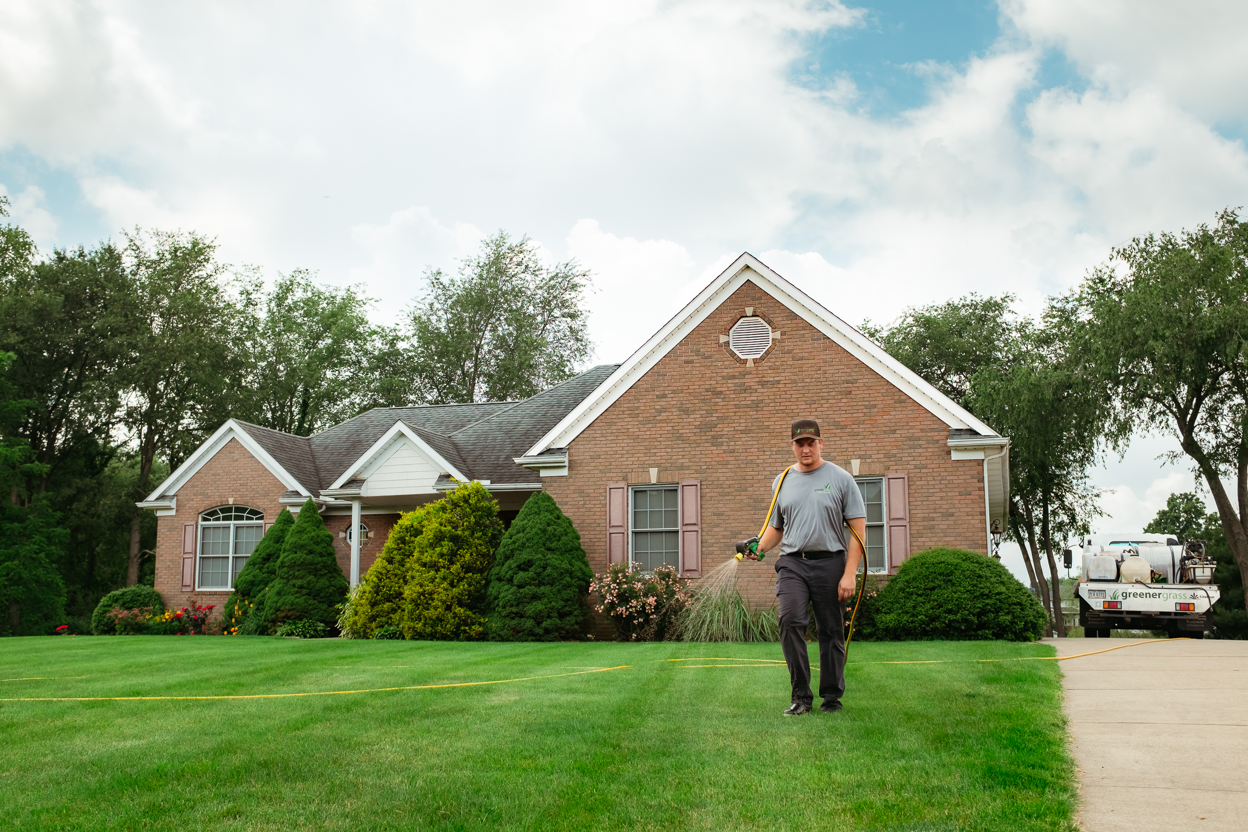 DSCF3545 (1) Greener Grass Organic Lawn Care worker applying fertilizer and weed control on Northeast Ohio lawn